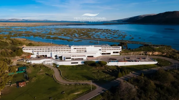 Hotel frente al Lago Titicaca en Puno, Perú, vista aérea que muestra la propiedad rodeada de áreas verdes y el paisaje del altiplano andino junto a la orilla del lago.