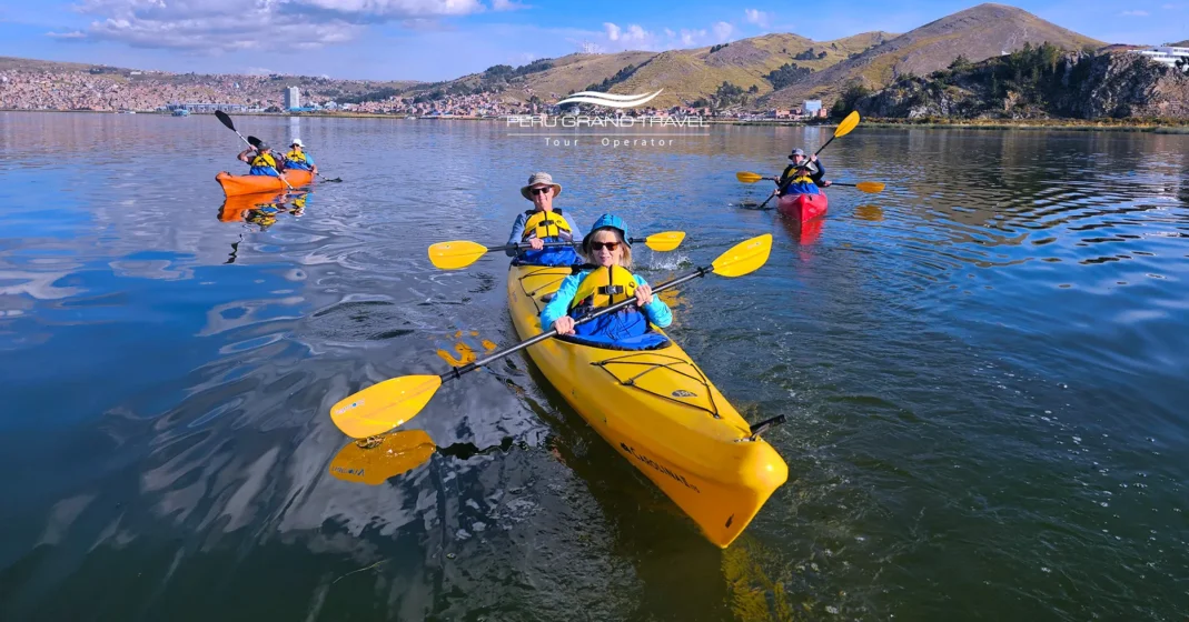 Cosas que Hacer en el Lago Titicaca: Principales Atracciones y Experiencias 1 Turistas haciendo kayak o paddleboard en el Lago Titicaca con montañas andinas de fondo.