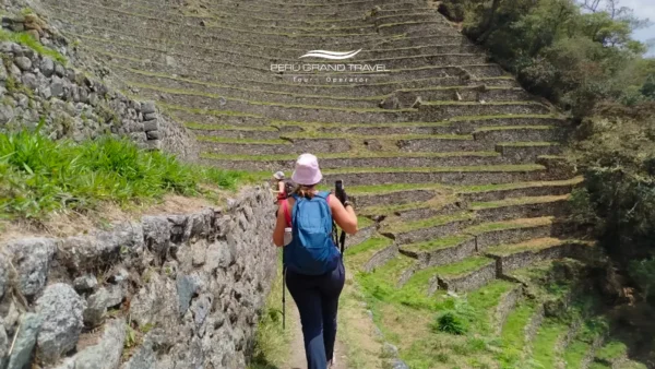 Senderista avanzando por el Camino Inca corto entre terrazas ancestrales de Wiñay Wayna, camino a Machu Picchu