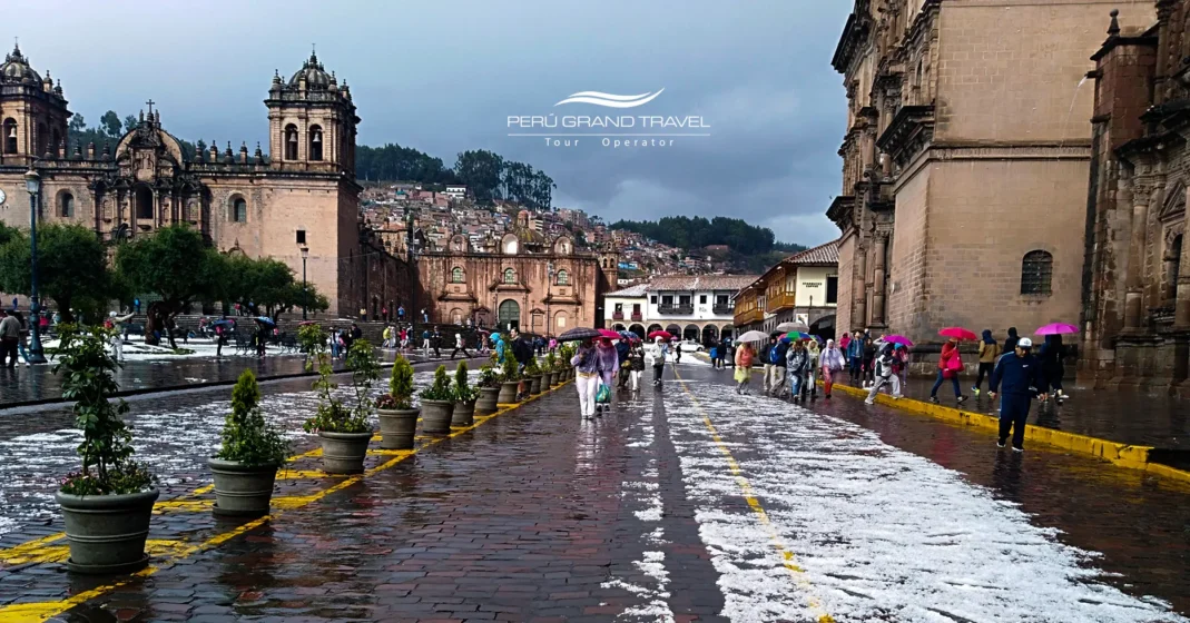 Clima en Cusco: Cuándo viajar, temperaturas y consejos para tu visita 2 Plaza de Armas del Cusco con calles húmedas, cielo nublado y reflejos sobre los adoquines tras una ligera lluvia. La imagen muestra la temporada de lluvias, cuando los paisajes se vuelven verdes, el aire se llena de frescura y la ciudad conserva su encanto bajo la llovizna andina.