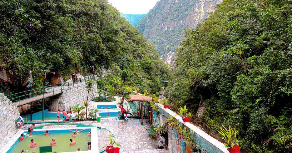 Baños termales en aguas calientes, piscinas de aguas calientes para relajarse después de conocer machu picchu en un día, paisaje lleno de montañas y plantas