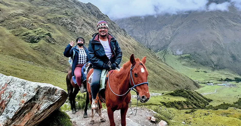 Subida de la laguna humantay con caballo y dos turistas posando a la cámara