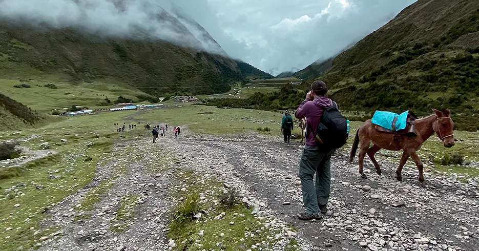 Camino de la laguna humantay, parte baja del camino con vegetación verde y el cielo nublado