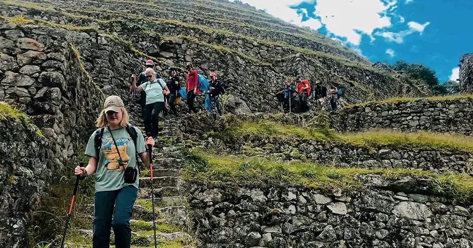 camino inca a machu picchu con varias personas bajando con sus bastones haciendo el trekking