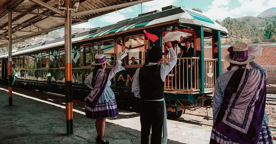 Los 12 Mejores Consejos para viajar a Perú 5 Consejos para viajar a Perú, bienvenida de tren Hiram Bingham, con trajes típicos de Perú
