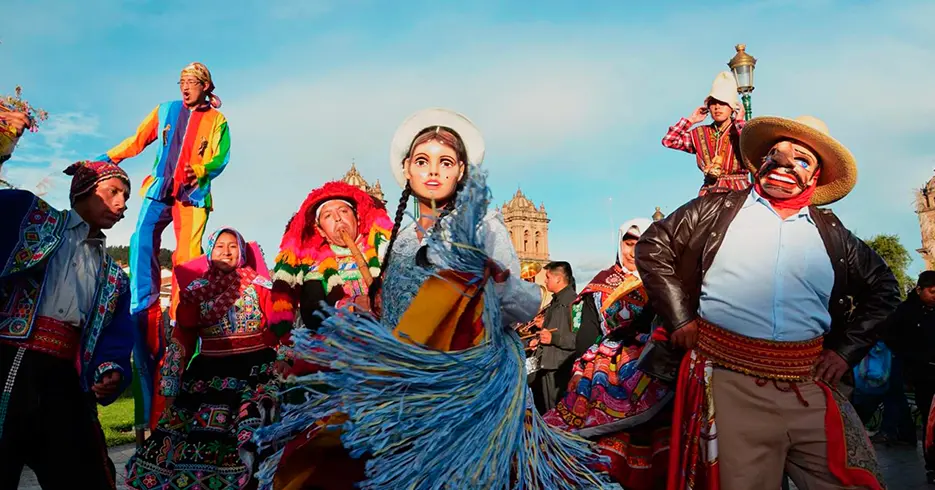 Viaje a los Andes en 11 días: Lugares impresionantes que debes conocer 7 Fiestas en cusco, danzas típicas de cusco, mujer bailando con una máscara y hombres bailando con sus trajes típicos y uno con una máscara
