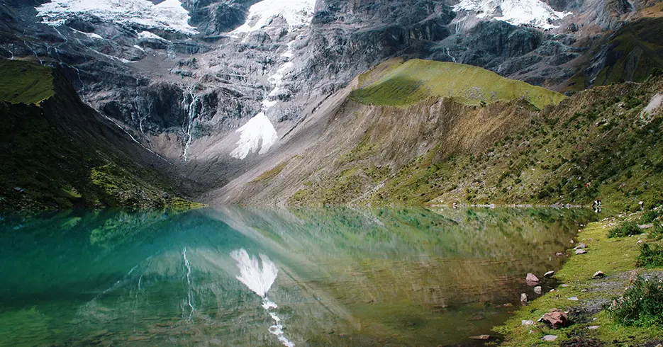 laguna humantay de cusco, laguna turquesa y cristalina con mucha vegetacion verde alrededor