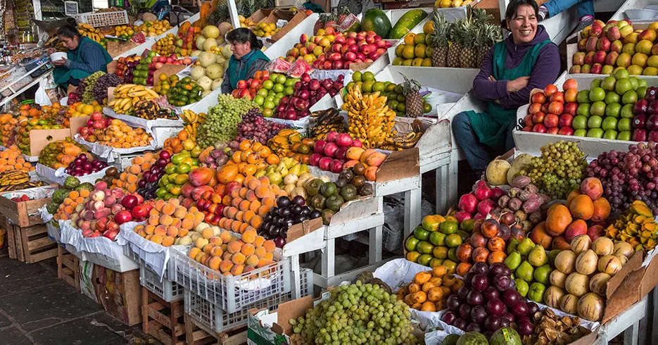 Viaja sin estrés: los mejores paquetes turísticos Cusco 6 Mercado San Pedro de cusco, en las partes de la fruta, se ven manzanas, plátanos, uvas, mango, durazno, ciruela y entre otras frutas