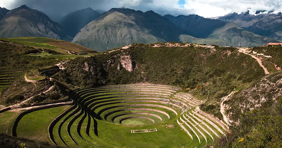 Viaje a los Andes en 11 días: Lugares impresionantes que debes conocer 4 Centro arqueológico de moray en cusco y en el valle sagrado de los incas, paisaje verde con montañas de fondo