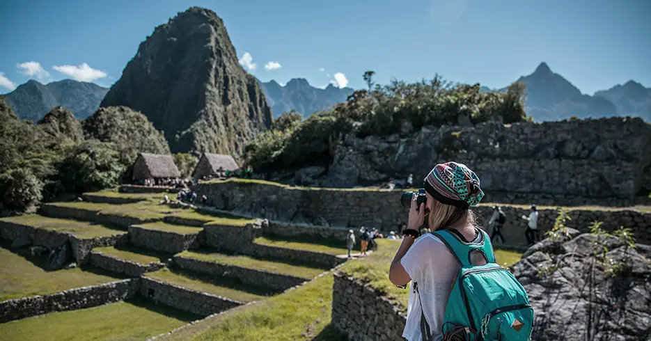 Turista fotografiando Machu Picchu en la plaza principal de Machu Picchu