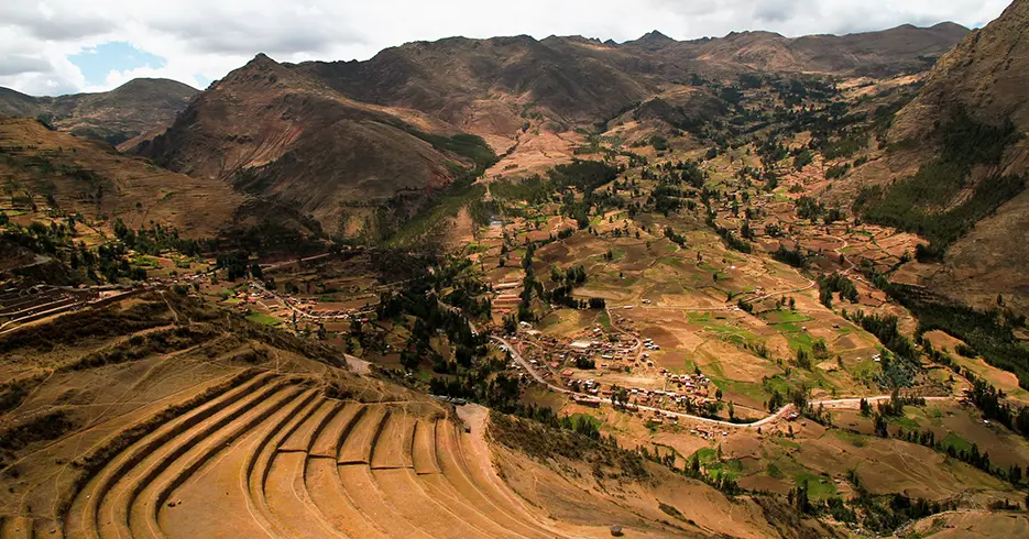Qué hacer en Cusco 4 Días: Todo lo que necesitas saber para una Experiencia Única 3 Centro arqueológico de pisac en el valle sagrado, se ve una vista de los andenes de este lugar y la vista que ofrece, llena de montañas y árboles con espacios verdes y marrones