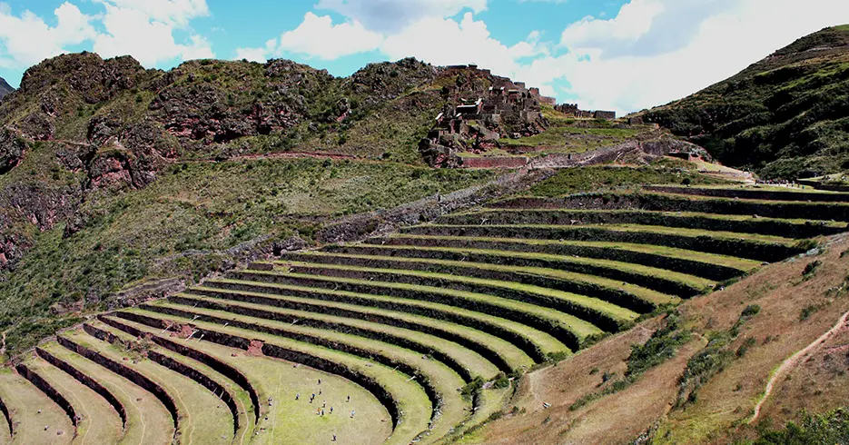Qué Hacer en Perú 10 Días: Tu Guía definitiva a la Aventura 3 Es el centro arqueológico de pisac en el valle sagrado en cusco, una vista de andenes verdes y en la parte baja se ven diferentes personas.