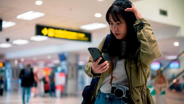 turista en el aeropuerto leyendo en su celular las recomendaciones de viaje a peru