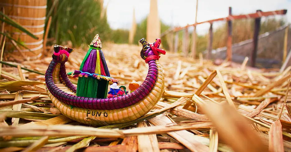Lugares para visitar en Puno Perú: Explora lo Mejor con Nosotros 4 Barco pequeño hecho de totora como una manualidad, que dice puno