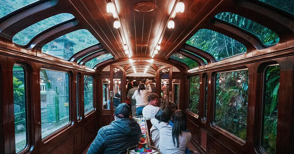 Explora Valle Sagrado Machu Picchu en 2 Días: Una Aventura Inca 7 Tren vistadome rumbo a cusco, turistas celebrando y algunos sentados