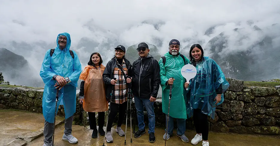 ¿Qué ropa llevar a Machu Picchu? La guía definitiva para viajeros 3 Qué ropa llevar a Machu Picchu, turistas en la lluvia de Machu Picchu con ponchos de lluvia y las montañas tapadas con la niebla
