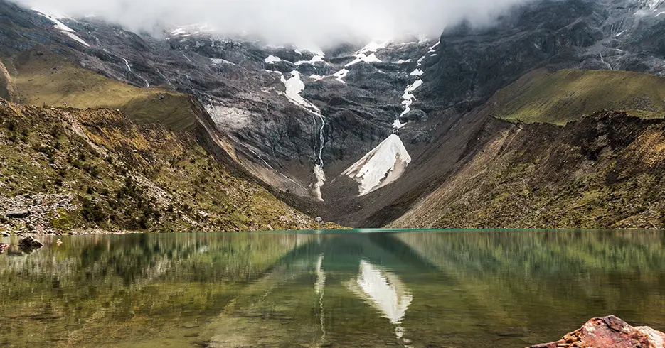 Vista despejada de la laguna humantay cusco, en la parte de arriba se puede ver montañas con nieve
